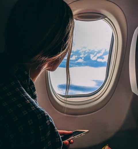 Kvinna vid flygplansfönster