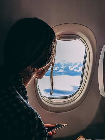 Kvinna tittar ut genom flygplansfönster